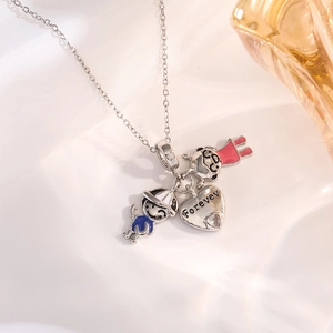 Macro detail of alloy necklace with enamel boy, girl charms and engraved heart pendant