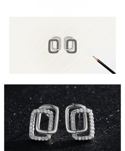 Macro view of interlocking geometric silver earrings with micro-paved cubic zirconia