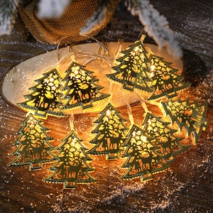 Christmas LED string lights with warm tree-shaped metal frames on rustic wooden background