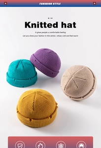 Detail of ribbed knit beanies with distressed edges in blue, purple, yellow, and beige