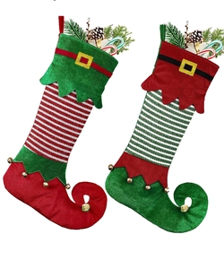 Detail of elf style Christmas stockings with curled toes, jingle bells and belt buckles