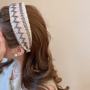 Gros plan d'un serre-tête tricoté brodé avec motifs ondulés et texture de tweed