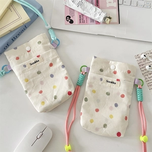 Detail of checkered canvas mini pouch with adjustable strap and polka dot pattern