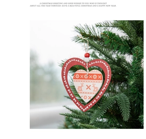 Close-up of double-layered wooden heart ornament with reindeer print on Christmas tree