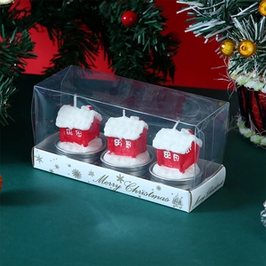 Set of three red cottage-shaped Christmas candles in a clear gift box with festive decor