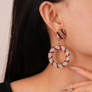 Macro shot of gold hoop earrings with red enamel stripes and sparkling rhinestones