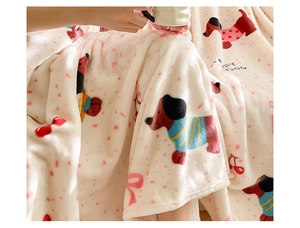 Close-up of thick flannel blanket featuring cartoon dogs and pink bow patterns