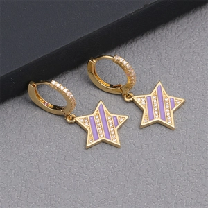 Macro shot of gold star earrings with purple enamel stripes and micro-set cubic zirconia