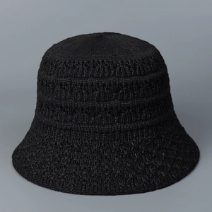 Close-up of black hollow knit bucket hat showing intricate crochet weaving details