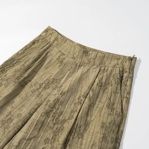 Detailed view of high-waist jacquard texture and invisible zipper on green floral pants