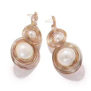 Detailed macro view of handmade wire-wrapped heart pearl earrings with gold and silver finish