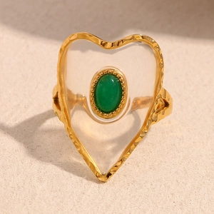 Macro shot of the 18K gold-plated heart ring with textured frame and green acrylic stone
