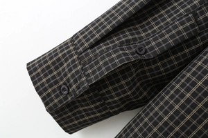 Close-up of long sleeve cuff with brown plaid pattern and double dark button details