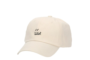 Close-up of smile embroidery and text on beige cotton baseball cap with curved brim