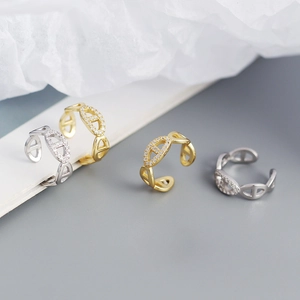 Detailed view of gold and silver pig nose ear cuffs with sparkling zircon stones