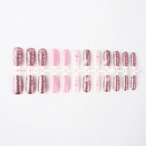 Detail of short glossy pink press-on nails with love heart patterns on display rack