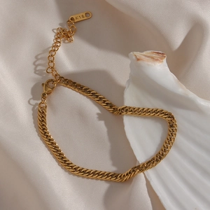 Detailed macro view of gold K18 Cuban chain link necklace with lobster clasp on silk