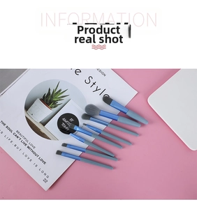 Detail of 8pcs mini sky blue makeup brush set with gray bristles on a pink surface