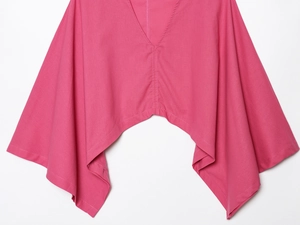 Détail du haut rose fuchsia en mélange de lin avec col en V et ourlet asymétrique