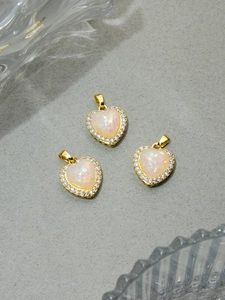 Detail of heart-shaped opal pendants with sparkling gold borders and crystal accents