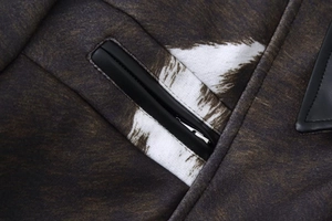 Detail of zipper pocket with brown animal print fabric and black leather trim accents