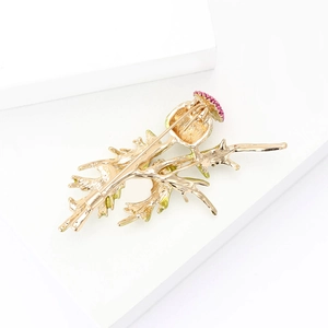Detailed view of alloy primrose brooch with pink stones on a white geometric stand