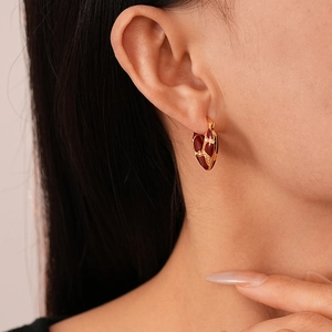 Orecchini vintage a cuore placcati in oro con smalto rosso e zirconi su modella