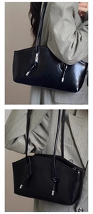 Detail of black glossy leather shoulder bag with knotted strap and silver metal accent