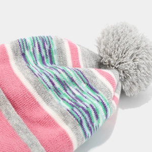 Close-up of vibrant multi-color striped knitted hat with a grey pompom and soft texture