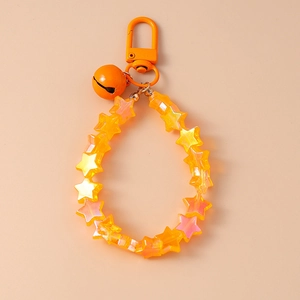 Macro view of star-shaped beads with orange gradient and matching metal bell charm