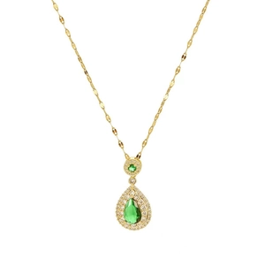 Golden teardrop necklace featuring emerald zircon stone and pavé diamonds on white background