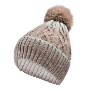 Detail of gradient cable knit winter hat with large faux fur pompom and ribbed cuff