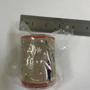Dettaglio del nastro natalizio in juta da 6cm con motivi di fiocchi di neve e alberi