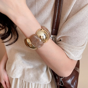 Detailed close-up of a wide marbled resin and gold metal segmented stretch bracelet