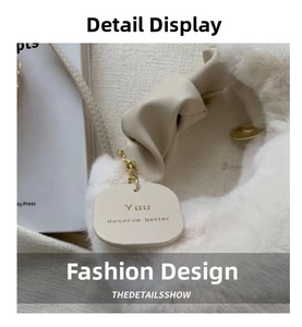 Close-up of white faux fur handbag detailing soft texture and gold chain strap