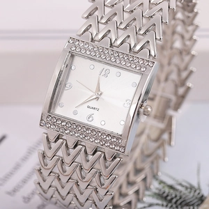 Close-up of a silver square quartz watch with diamond bezel and V-shaped metal link strap