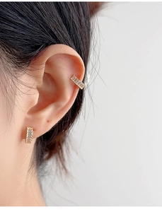 Close-up of S925 silver C-shaped ear cuff and stud set with baguette zircons
