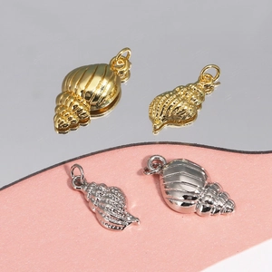 Lot de quatre pendentifs coquillages en or et argent avec finition métallique polie