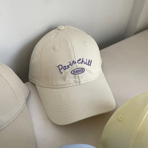 Close-up of Paris chill RADIO embroidery on a cream cotton soft top baseball cap