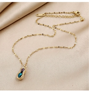 Détail du pendentif en forme de cacahuète avec pierres précieuses sur soie beige