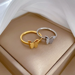 Minimalist butterfly titanium steel rings in gold and silver finish on jewelry box