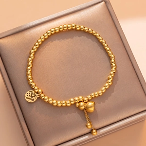 Golden titanium steel beads bracelet with Fu character and gourd charms on a gift box