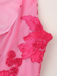 Close-up of pink mesh fabric with detailed 3D floral embroidery on the shoulder