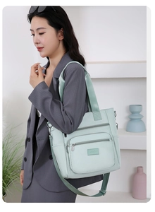 Close-up of mint green Oxford cloth shoulder bag with multiple functional zipper pockets