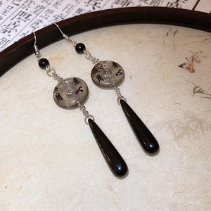 Detailed close-up of retro Chinese style resin fan earrings with calligraphy engraving