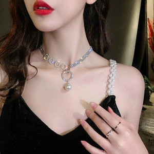 Elegant silver necklace featuring sparkling pavé rings and a white freshwater pearl pendant