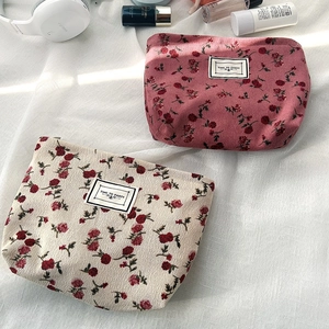 Macro view of floral corduroy cosmetic bags in pink and beige with Time to Party tags