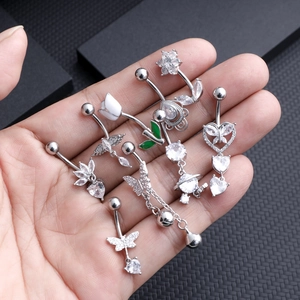 Silver belly button rings with zircon butterfly and heart pendants on black background