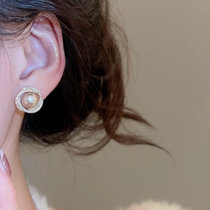 Close-up of champagne pearl earrings with double-layered zircon circles on ear