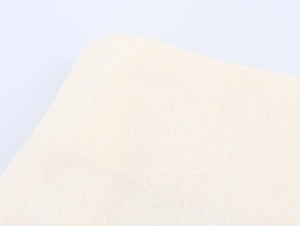 Detailed macro shot showing the soft knitted texture of the cream white resort wear fabric